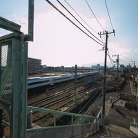 三鷹跨線人道橋から眺めるJR線路と通過する列車の写真