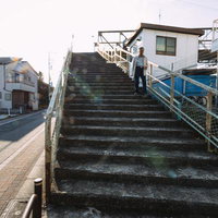 JR三鷹駅近くの陸橋に上がるコンクリート階段と跨線橋の写真