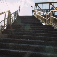 日が落ちた時間帯の三鷹跨線人道橋を上る階段の写真