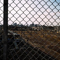 三鷹跨線橋から見える金網越しのJR車両センターの写真