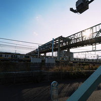 JR三鷹駅の跨線橋前に立つバス停と陸橋の駅前風景の写真