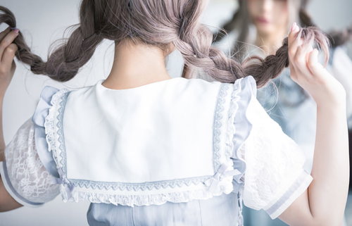 三編みヘアスタイルの鏡の前でハッピーな後ろ姿