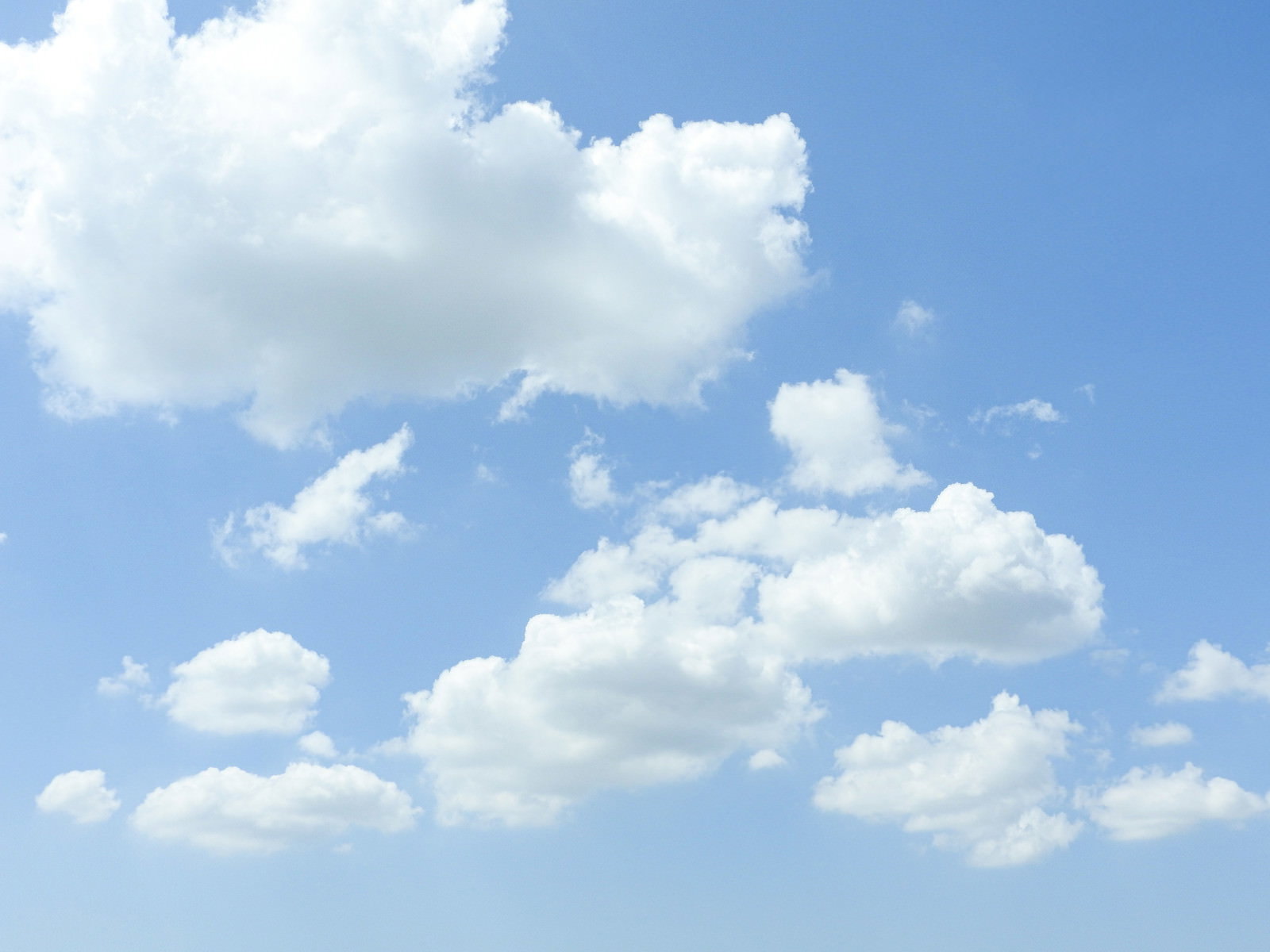 青空に大小の白い雲がふわふわと浮かんでいる爽やかな風景