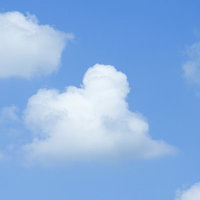 青空に浮かぶ白い雲がプカプカと流れる風景の写真