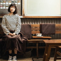 カリオモンズコーヒーのレトロな店内でくつろぐ女性の写真
