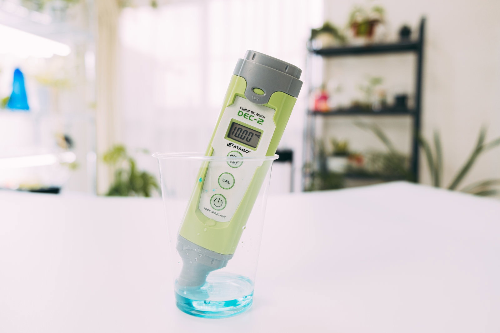 EC meter for measuring the concentration of liquid fertilizer placed on a white table