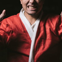 サンタコスをした男性が両手を広げてポーズを取ったの写真
