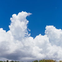 白い砂浜から見上げた青空と大きな積乱雲の写真