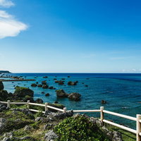 宮古島の岩礁海岸から望む青い海と水平線、崖上からの沖縄の絶景の写真