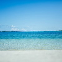 宮古島の四層の風景、エメラルドグリーンの海と白い砂浜の写真