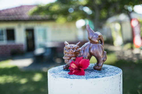 宮古島の狛犬の置物と赤いハイビスカス、沖縄文化の象徴