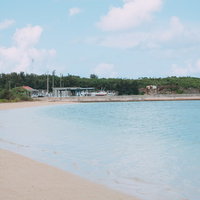 宮古島の透明な海岸に寄せる穏やかな波と白い砂浜の写真