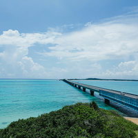 青い海へと続く伊良部大橋と白い砂浜、エメラルドグリーンのリゾート風景の写真
