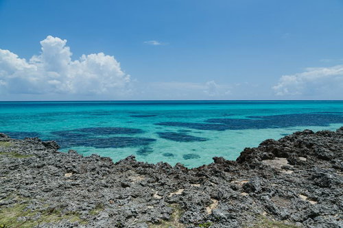 宮古島の海岸から見たエメラルドグリーンの海と水平線、積乱雲