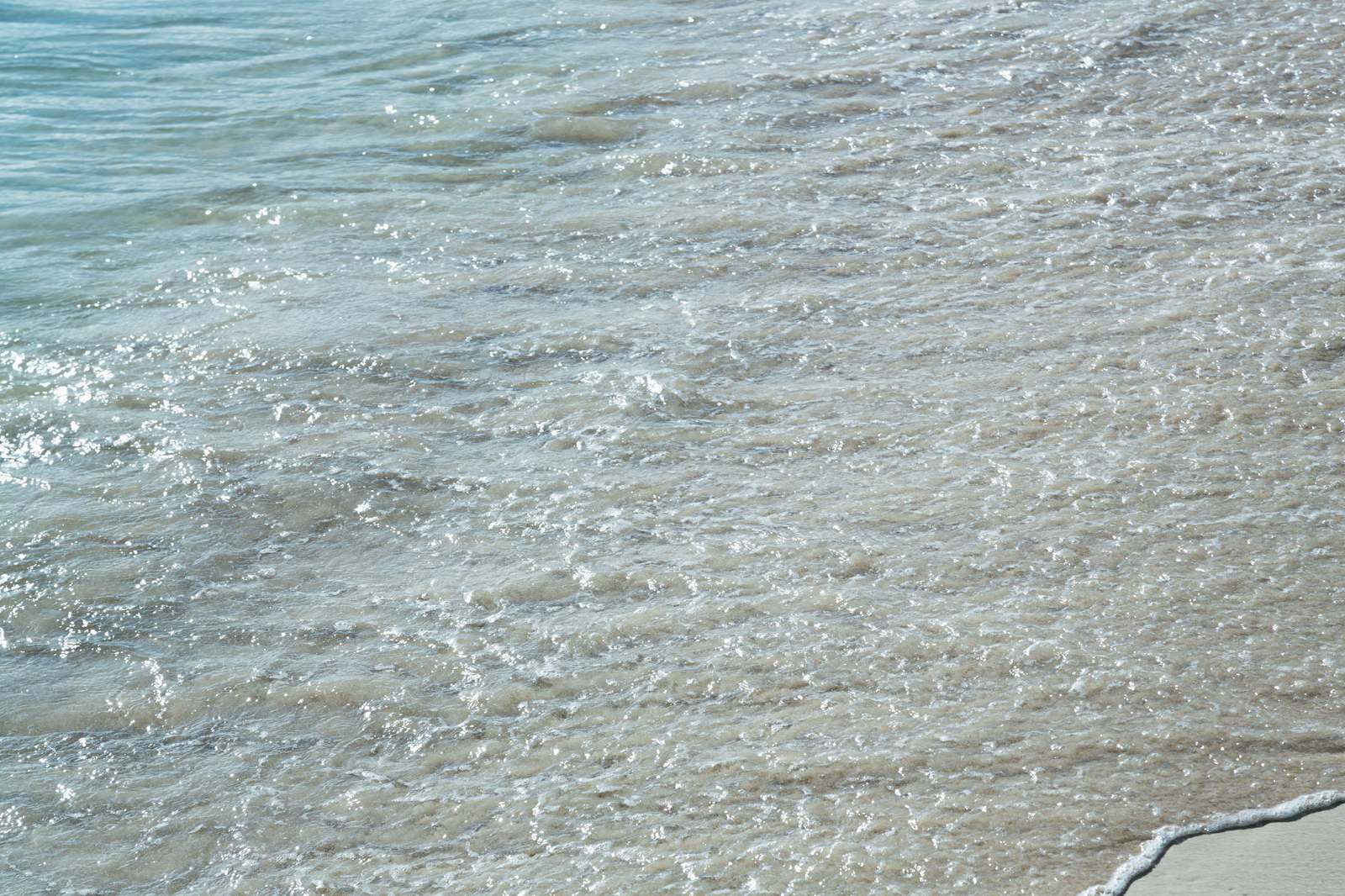 宮古島の海水浴場で波立つ波打ち際と砂浜