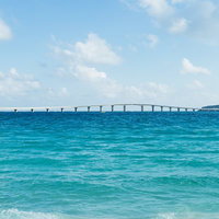 宮古島のエメラルドグリーンの海に架かる伊良部大橋と水平線の写真