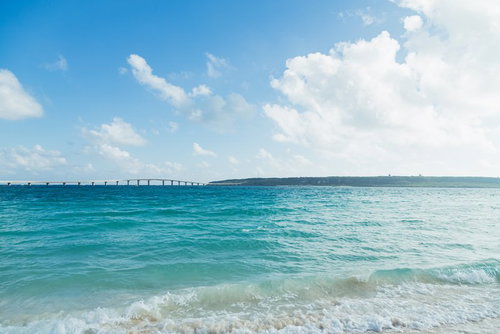 遠景に伊良部大橋が見える宮古島のエメラルドグリーンの海