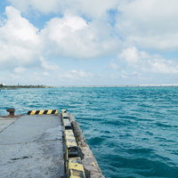 沸き立つ雲と宮古島の港、伊良部大橋を望むの写真