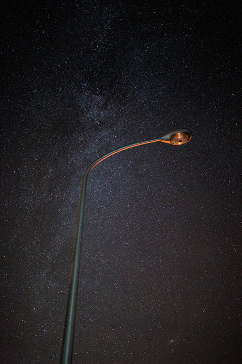 街灯と天の川が輝く夜空の星景