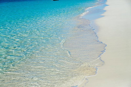 宮古島の穏やかに寄せる透明な波と白い砂浜