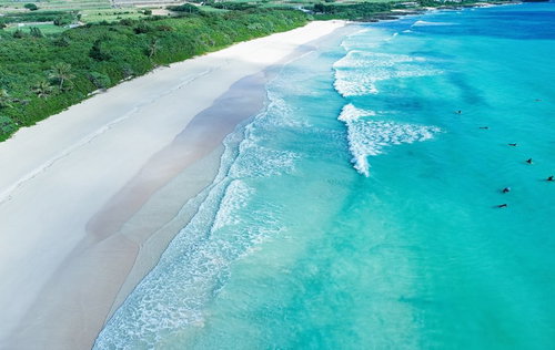 宮古島の浜辺で波待ちするサーファーたちの風景