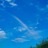 宮古島の青空に架かる虹と白い雲の写真