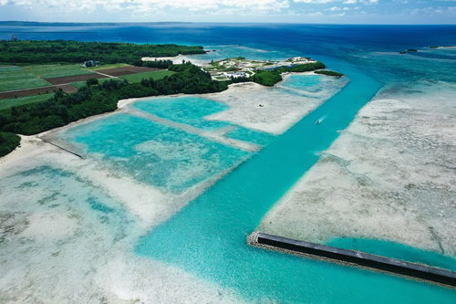 宮古島の透明度の高い海を進むボートの写真