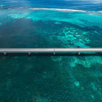 宮古島の透き通った海を渡る伊良部大橋のターコイズブルーの絶景の写真