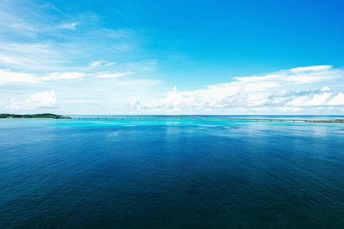宮古島から望む伊良部大橋と透明度の高いエメラルドブルーの海の写真