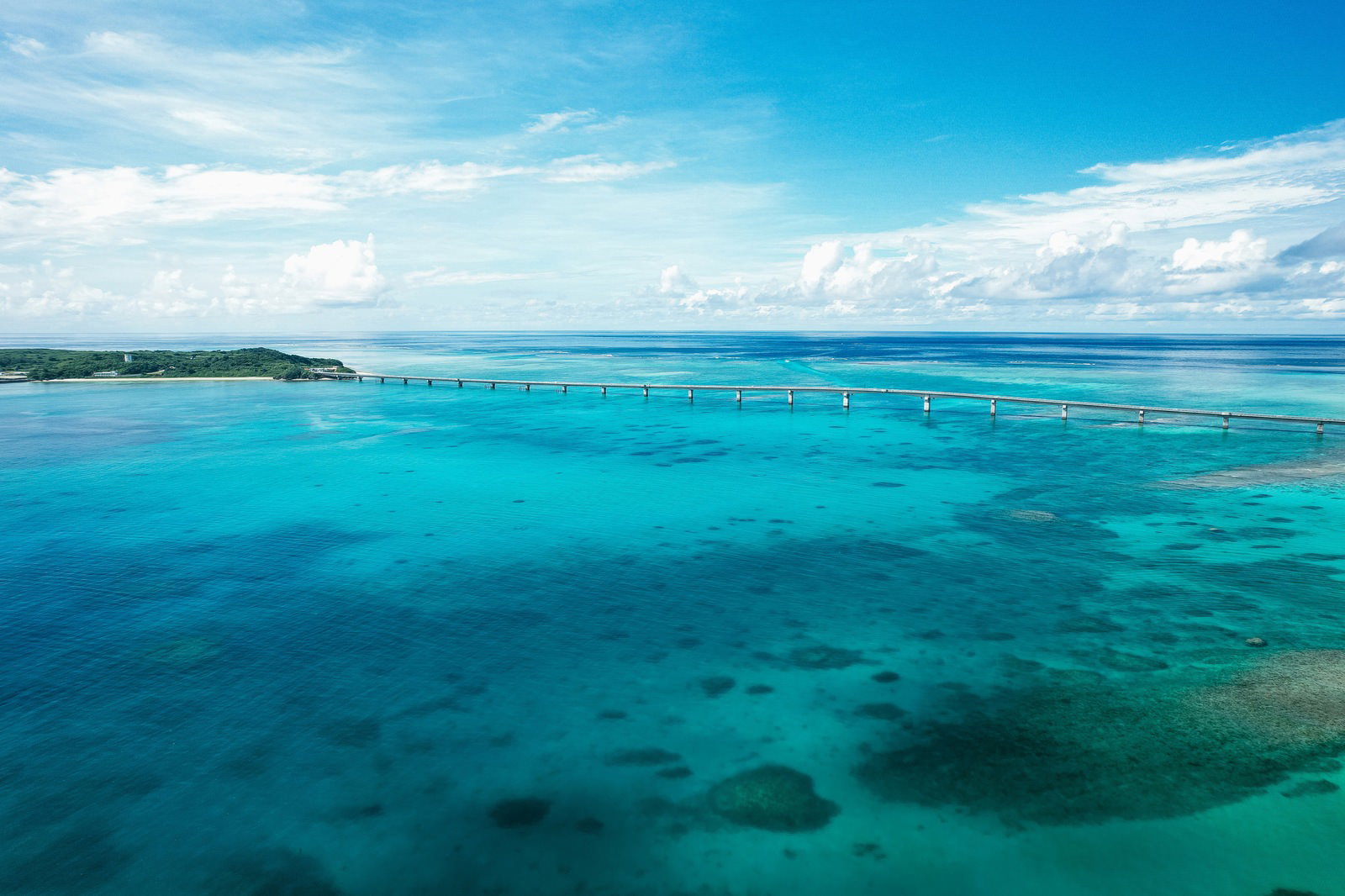 エメラルドグリーンの海に架かる伊良部大橋と青空の風景