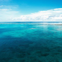 澄み切った海に伸びる宮古島の伊良部大橋と水平線の写真