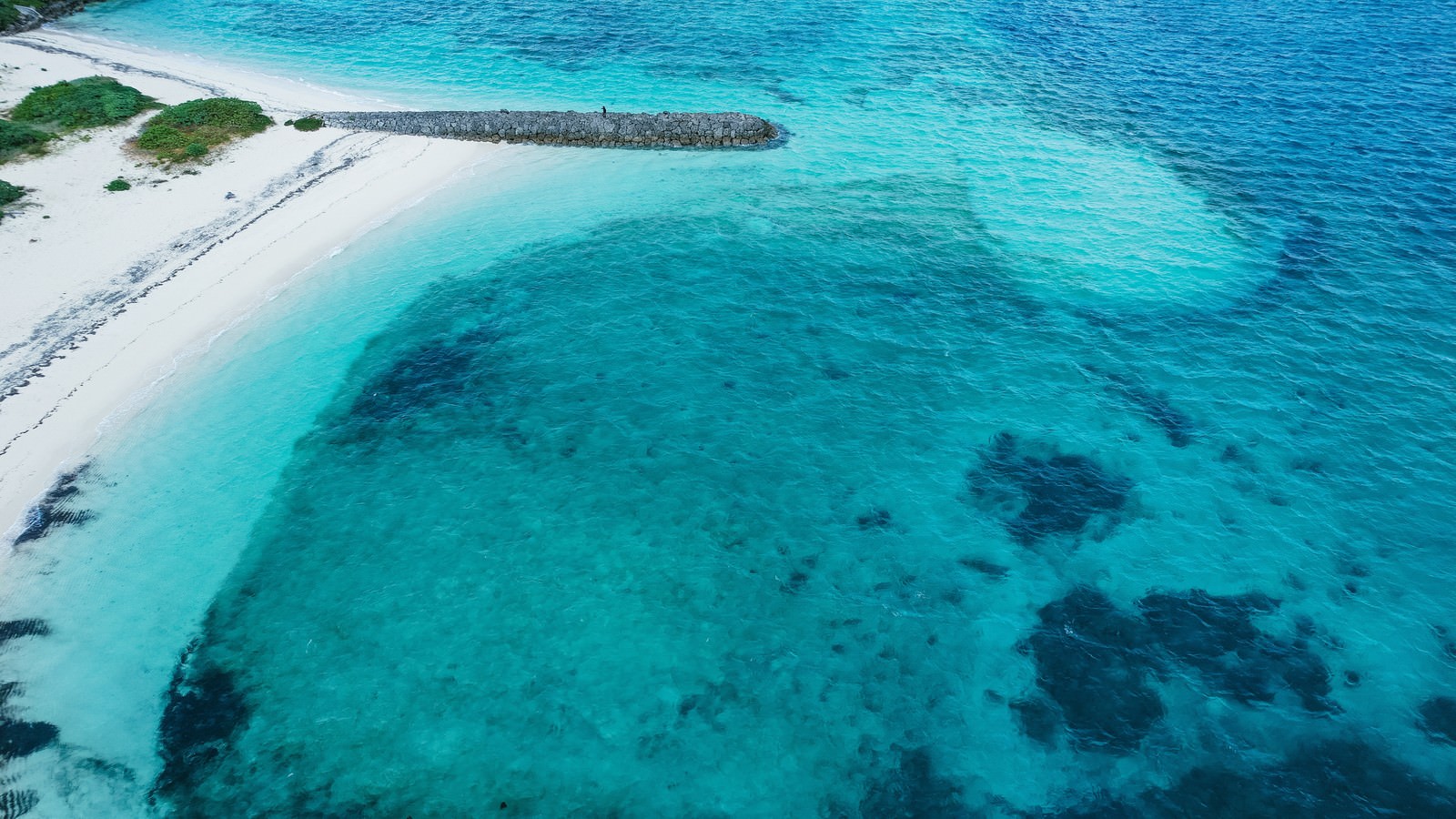 宮古島の透明度の高いエメラルドグリーンの海と白い砂浜の航空写真