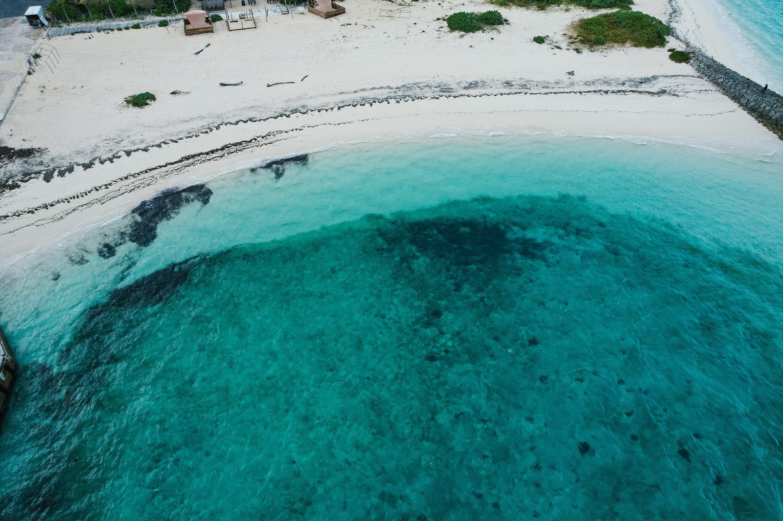 Aerial view of the transparent emerald green waters and white sand beaches of Miyakojima
