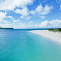 宮古島の白い砂浜が続く海と透明なエメラルドグリーンの海水浴場の写真