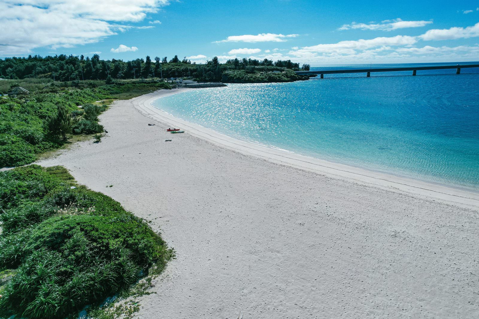 青い海と白い砂浜の海水浴場から見える伊良部大橋の風景