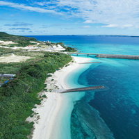 青空の下、海にせり出す伊良部大橋の写真