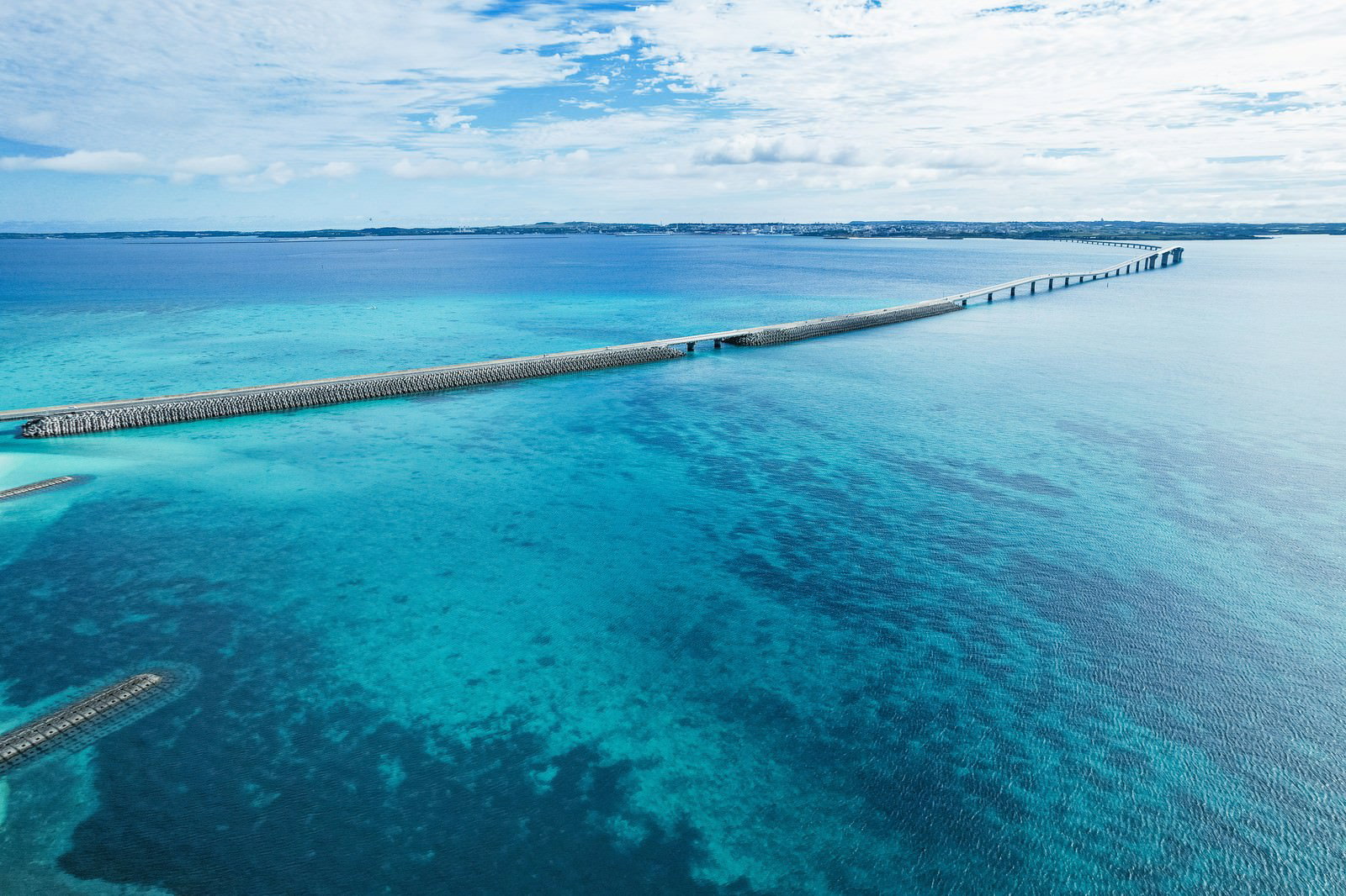 Aerial photograph of the Irabu Bridge spanning the crystal-clear waters of Miyakojima
