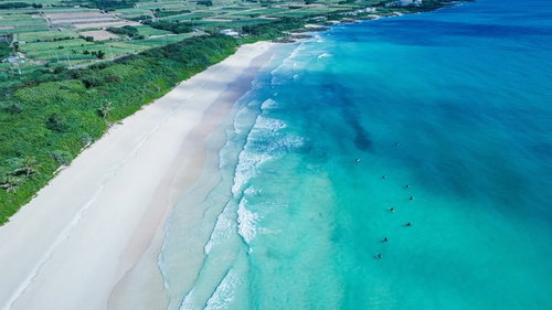 宮古島の波を待つサーファーとエメラルドグリーンの海