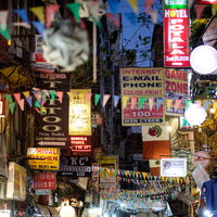 ネパール・カトマンズの夜の繁華街、色とりどりの看板と張り紙が並ぶ商店街の写真