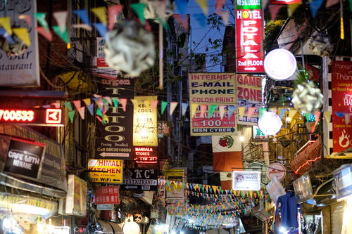 ネパール・カトマンズの夜の繁華街、色とりどりの看板と張り紙が並ぶ商店街
