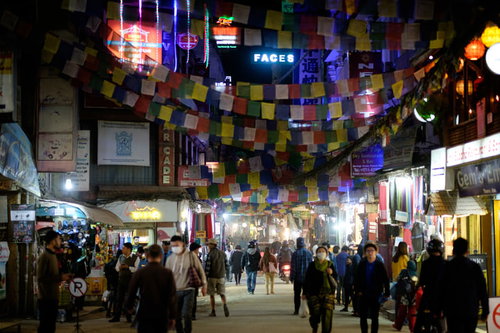 カラフルな紙が吊るされたカトマンズの繁華街の人混み