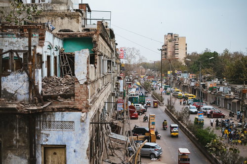ニューデリーの倒壊しそうな建物と交通量の多い大通り