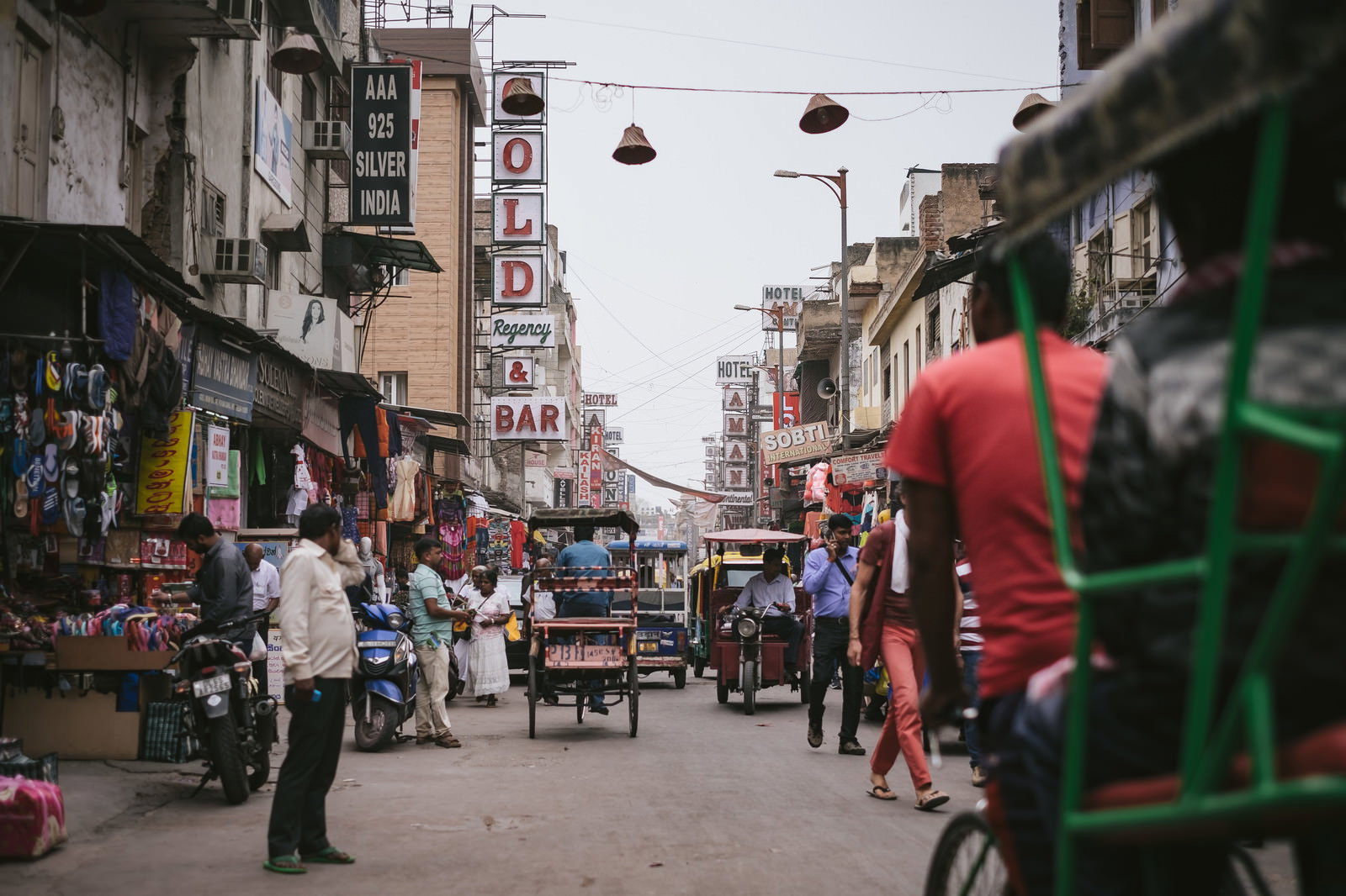 インド・ニューデリーの商店街で三輪自転車が行き交う賑やかな通りの風景