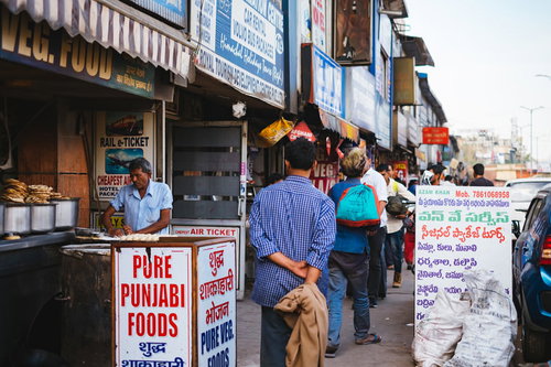 食事時に混み合うニューデリーの歩道と屋台