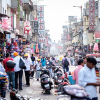 インド・ニューデリーの大きな商店街の路地で作業する男性の写真