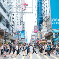 香港都市部の高層ビル群と人混みする横断歩道の写真