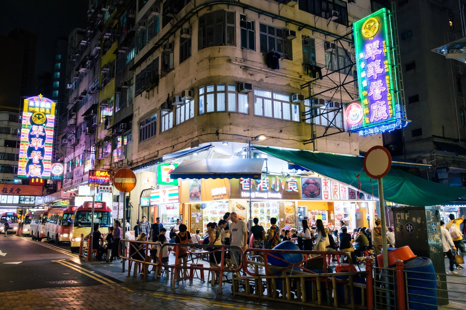 ネオンサインが輝く香港の繁華街で人々が行き交う夜の風景