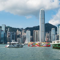 香港のビル群と海上の遊覧船、都市と海景を映した風景の写真