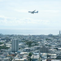 函館空港から離陸した旅客機と住宅地の街並みの写真