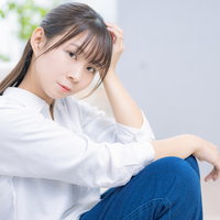 ソファーにもたれかかり考える女性の写真